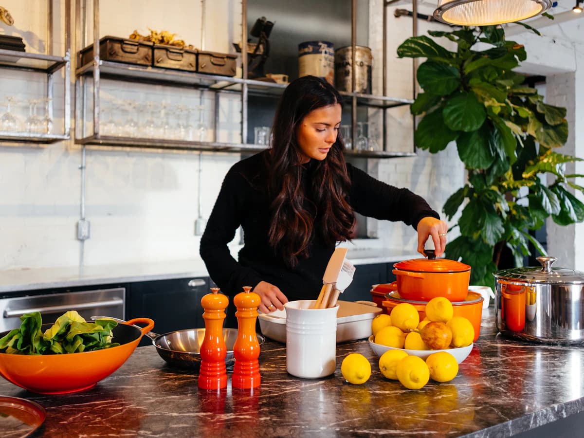 Mujer cocinando con frutas y verduras frescas en una cocina